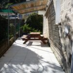 grande terrasse avec un banc en bois et une vue sur un beau jardin