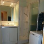 salle de bain équipée d'une lave linge et douche à l'italienne pour les amateur des vacances à la plage